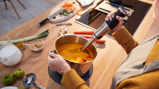 Immersion blender in pan with soup