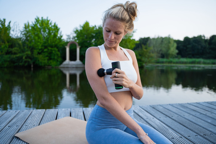 Tunturi Massage Gun Mini + Massage Head Warm and Cool product in use