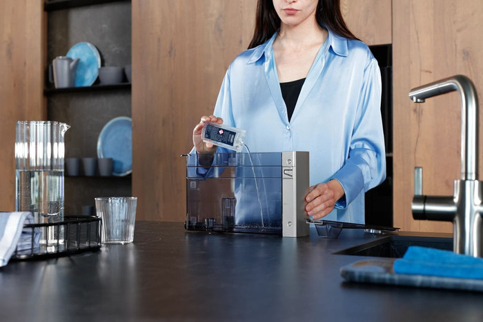 De'Longhi Rivelia EXAM440.55.G + Descaler product in use